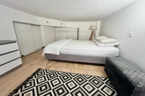 - une chambre avec un grand lit blanc et un tapis dans l'établissement Golfe Juan - 4 People - Swimming Pool - Parking, au Golfe-Juan