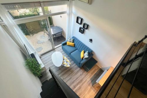 - un salon avec un canapé bleu dans l'établissement Golfe Juan - 4 People - Swimming Pool - Parking, au Golfe-Juan