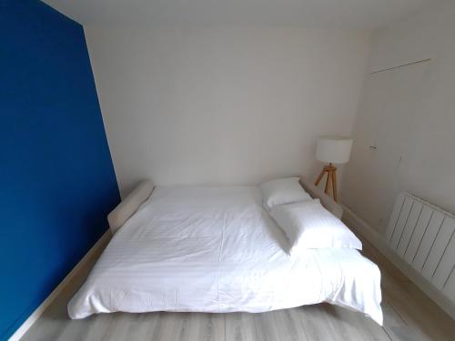 Ce lit se trouve dans un dortoir doté de draps et d'oreillers blancs. dans l'établissement Le Perdrix 2 - Studio 2 prs, proche centre ville, à Dijon