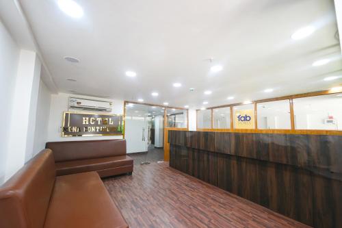 a waiting room with a couch and a sign at FabHotel Mona Continental - Nr Laxmi Nagar IT Hub in New Delhi