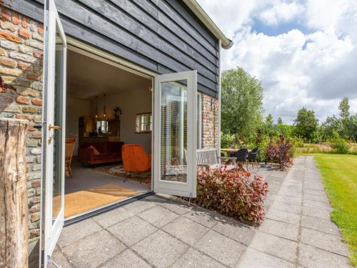 an open door on a house with a patio at Holiday Home De kleine Pionier by Interhome in Grijpskerke