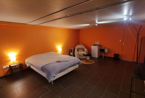 una camera con pareti arancioni e un letto in una stanza di Studio dans les boucles de Seine proche de Rouen a Saint-Pierre-de-Manneville