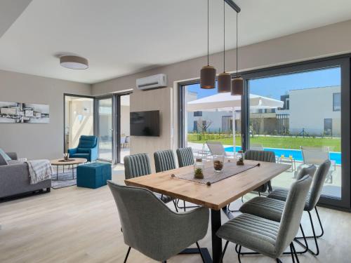 ein Esszimmer und ein Wohnzimmer mit Tisch und Stühlen in der Unterkunft Villa Bella by Interhome in Brtonigla