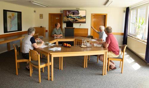 eine Gruppe von Menschen, die um einen Tisch herum sitzen in der Unterkunft Gästehaus Bleckmar in Bergen