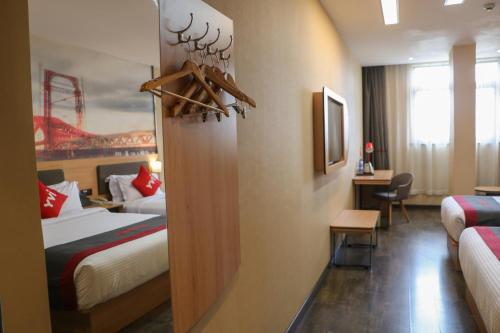 a hotel room with two beds and a desk at IVY Hotel Addis Ababa Airport branch in Addis Ababa