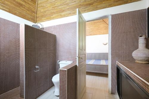 a bathroom with a toilet and a glass shower at Villa Nianing in Nianing