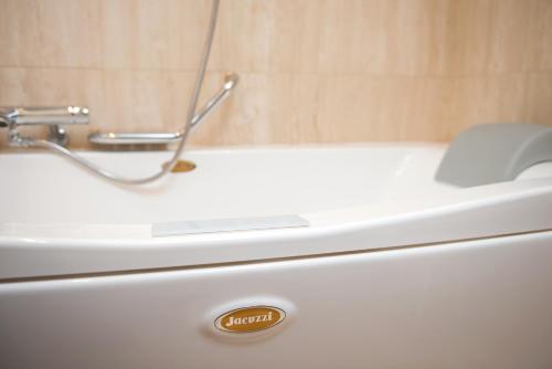 a white bath tub sitting next to a white sink at Hotel Promenade in Montesilvano