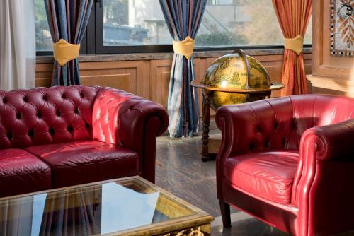 a living room with two leather chairs and a glass table at Hotel Promenade in Montesilvano