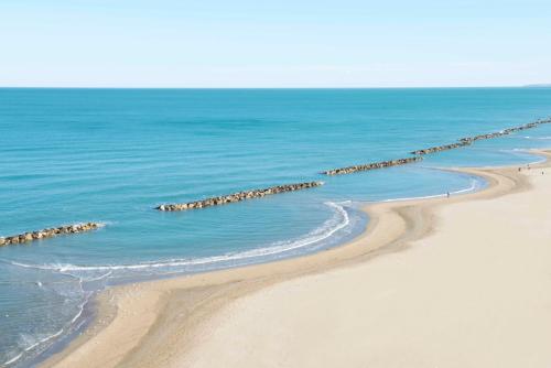 a beach with a group of rocks in the water at Hotel Promenade in Montesilvano