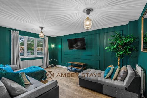 レディングにあるSpacious 5 Bed House in Reading by Amber Stays, Perfect for Business & Contractors, Sleeps 12の緑の壁のリビングルーム(ソファ付)