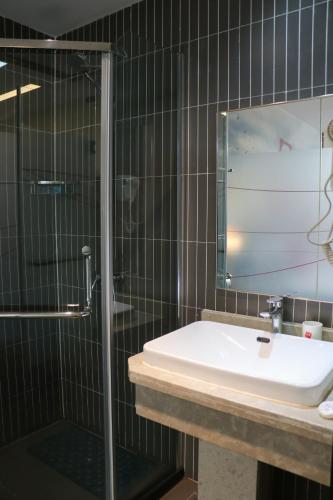 a bathroom with a sink and a glass shower at IVY Hotel Addis Ababa Airport branch in Addis Ababa