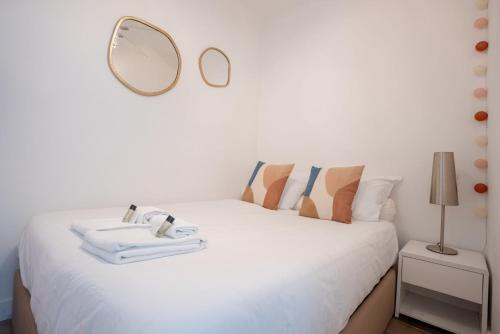 - une chambre avec un lit blanc et un miroir mural dans l'établissement The Beach Cocoon – Sea View & Calm, à Cannes