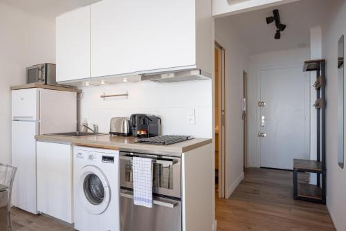 une cuisine avec un lave-linge et un sèche-linge sur un comptoir dans l'établissement The Beach Cocoon – Sea View & Calm, à Cannes