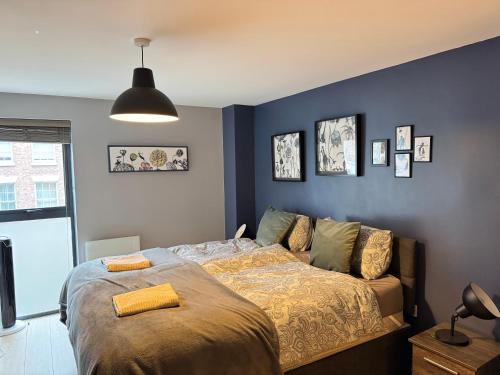 a bedroom with a bed and a blue wall at Centrally located apartment in Duke Street- free parking- two bathrooms in Liverpool
