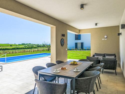 a dining room with a table and chairs and a pool at Villa Chiara by Interhome in Brtonigla