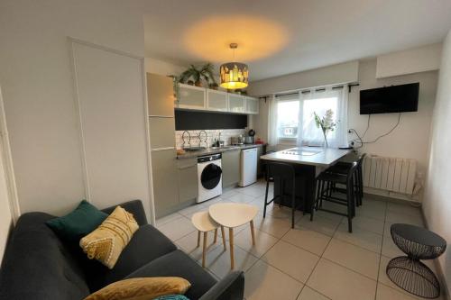 un salon et une cuisine avec un canapé et une table dans l'établissement La plage d'Augustin, au Havre
