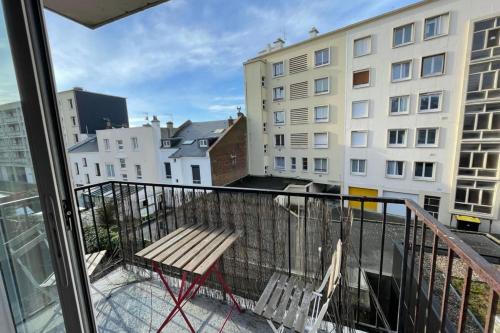 d'un balcon avec un banc et une vue sur un bâtiment. dans l'établissement La plage d'Augustin, au Havre