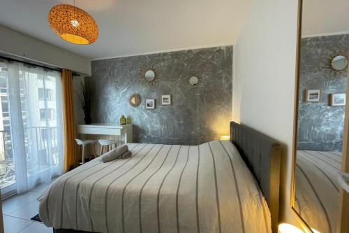 une chambre avec un lit et un grand miroir dans l'établissement La plage d'Augustin, au Havre