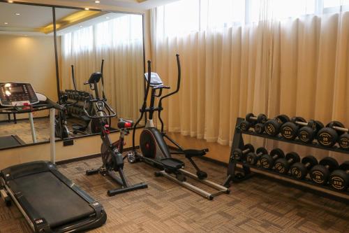 a gym with exercise bikes and a mirror at IVY Hotel Addis Ababa Airport branch in Addis Ababa