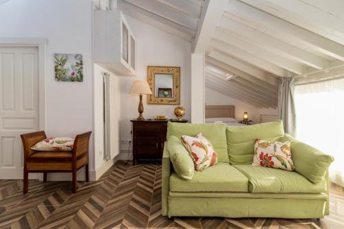 a living room with a green couch and a bedroom at Casa Bederna in Comillas