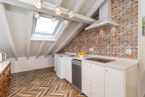 a kitchen with white cabinets and a window at Casa Bederna in Comillas