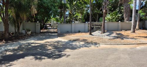 a street with a fence and trees and a sign at Fairway Lodge in Pongola