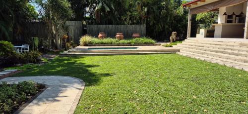 a yard with stairs and a fence and a yard with grass at Fairway Lodge in Pongola