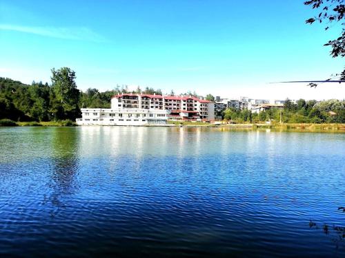 a large building sitting on top of a large lake at Tryavna Lake Apartment in Tryavna