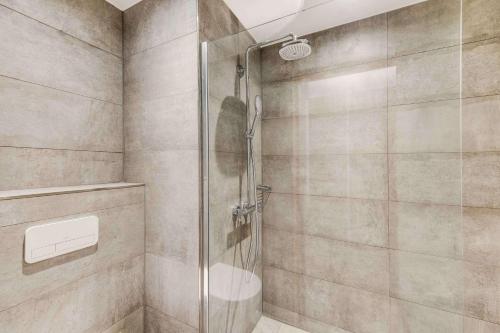 a shower with a glass door in a bathroom at NH Brussels Airport in Diegem