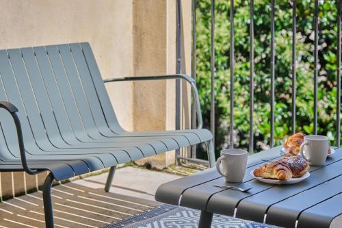une table avec deux tasses et un plateau de croissants dans l'établissement Au Céladon Parking gratuit, WIFI, Terrasse, Piscine, à Carcassonne