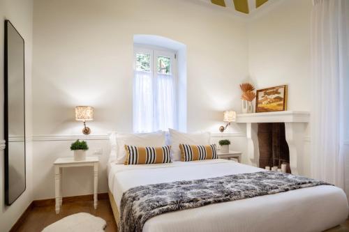 a white bedroom with a bed and a window at Archontiko Parnassus Dadi in Amfiklia