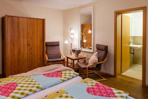 a bedroom with two beds and a table and chairs at Landhaus Wern's Mühle in Ottweiler