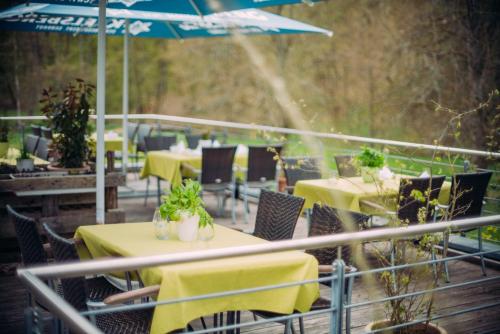 a restaurant with tables and chairs and an umbrella at Landhaus Wern's Mühle in Ottweiler