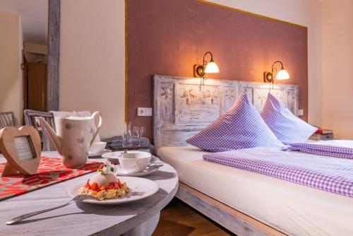 a bedroom with two beds and a table with a plate of food at Landhaus Wern's Mühle in Ottweiler