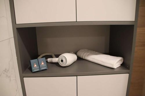 a cupboard with towels and a fan and a book at Dream residence Lux apartment Zlatibor in Zlatibor