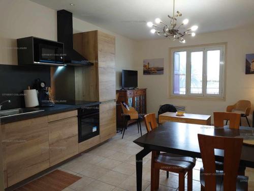 une cuisine avec une table et une salle à manger dans l'établissement 4DEMO46 - Collioure appartement T2 plage et vue, à Collioure