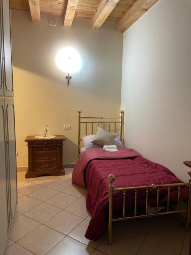 a bedroom with a bed and a table and a lamp at Villa Rondine in Corno Alto