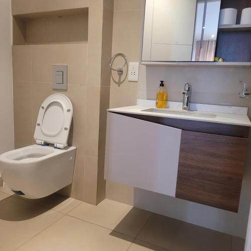 une salle de bains avec toilettes et lavabo dans l'établissement RT LUXURY ONE BEDROOM DUPLEX At BELROSE PLACE, à Accra