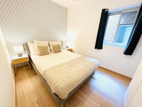 une chambre avec un lit dans une pièce avec une fenêtre dans l'établissement 3 - Hypercentre, FREE Parking, Climatisation, wifi, netflix, à Libourne