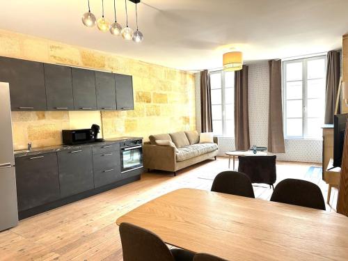 une cuisine et un salon avec une table et un canapé dans l'établissement 3 - Hypercentre, FREE Parking, Climatisation, wifi, netflix, à Libourne