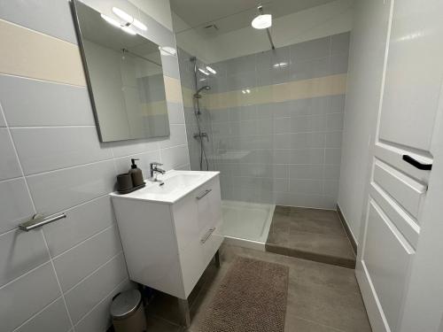 une salle de bain blanche avec un lavabo et une douche dans l'établissement 3 - Hypercentre, FREE Parking, Climatisation, wifi, netflix, à Libourne