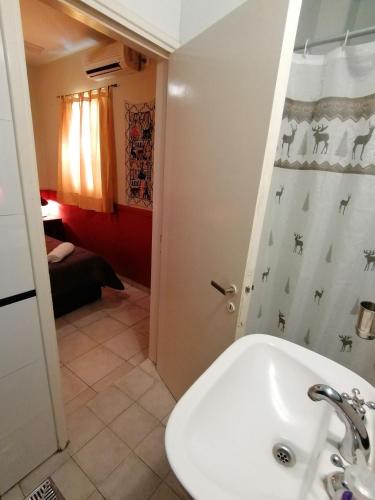 a bathroom with a sink and a shower curtain at Alamo Hostel & Suites in Mendoza