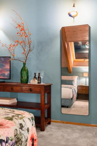 a bedroom with a mirror and a table and a bed at Archontiko Parnassus Dadi in Amfiklia