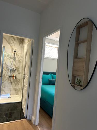 - un miroir mural dans une chambre avec un canapé bleu dans l'établissement Cosy 2 p au coeur de menton, à Menton