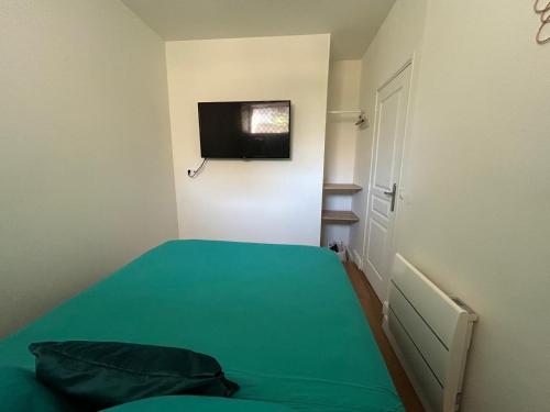 Cette petite chambre comprend un lit et une télévision à écran plat. dans l'établissement Cosy 2 p au coeur de menton, à Menton