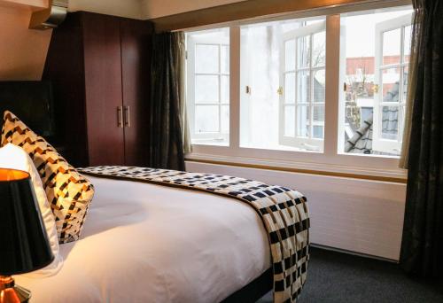 a bedroom with a large bed and a window at Ambassade Hotel in Amsterdam