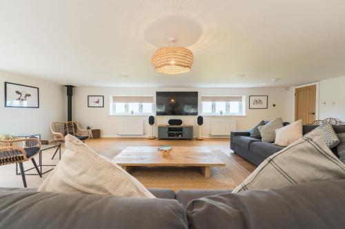 a living room with a couch and a coffee table at Tan Y Fron By Birch Stays in Pentraeth