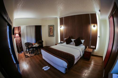 a hotel room with a large bed and a desk at Tolip Inn Maadi in Cairo