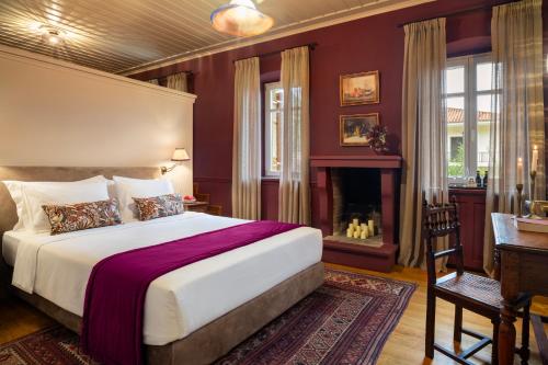 a bedroom with a large bed and a fireplace at Archontiko Parnassus Dadi in Amfiklia