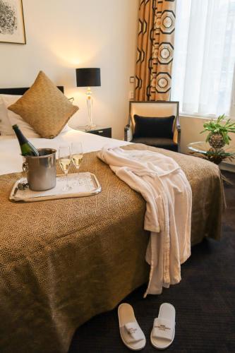 a hotel room with a bed with a tray of wine glasses at Ambassade Hotel in Amsterdam